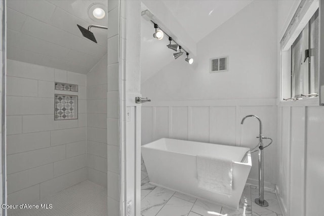1922 E Rodkey Dr, Post Falls, ID 83854 - bathroom featuring vaulted ceiling, a freestanding bath, marble look tile flooring, a wainscoted wall, and tiled shower