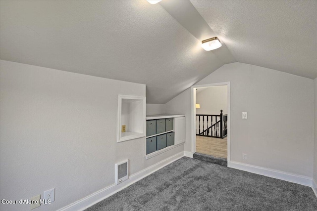 1922 E Rodkey Dr, Post Falls, ID 83854 - additional living space featuring a textured ceiling, vaulted ceiling, and dark carpet