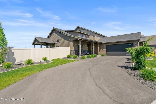 3811 N Foxtail Rd, Post Falls, ID 83854 - view of front facade with covered porch, asphalt driveway, an attached garage, and stone siding