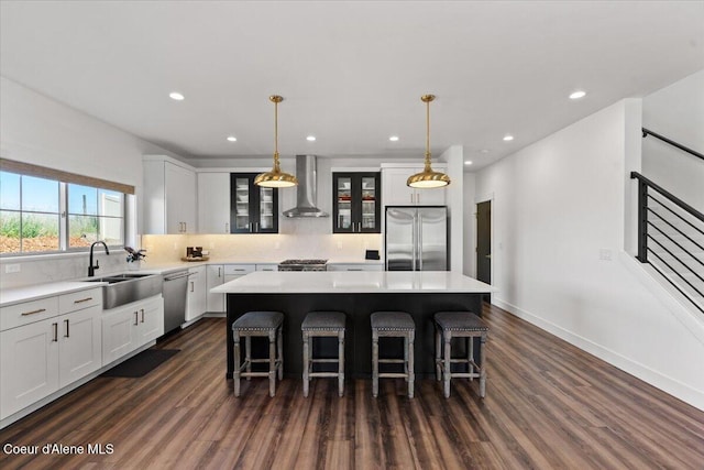3811 N Foxtail Rd, Post Falls, ID 83854 - kitchen with stainless steel appliances, wall chimney exhaust hood, dark wood-type flooring, a center island, and recessed lighting