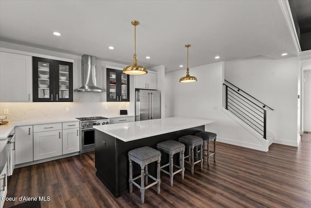 3811 N Foxtail Rd, Post Falls, ID 83854 - kitchen featuring wall chimney exhaust hood, premium appliances, dark wood-style floors, a center island, and glass insert cabinets