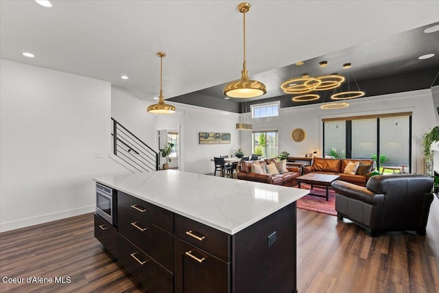 3811 N Foxtail Rd, Post Falls, ID 83854 - kitchen with stainless steel microwave, dark wood-style floors, pendant lighting, open floor plan, and a center island