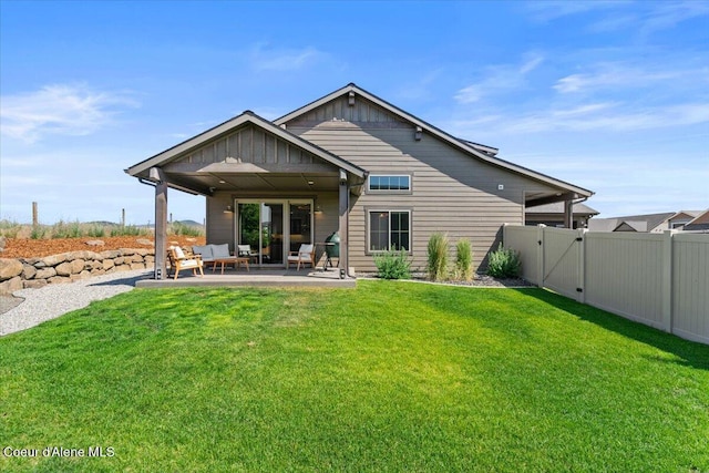 3811 N Foxtail Rd, Post Falls, ID 83854 - rear view of property featuring a patio, an outdoor hangout area, board and batten siding, and a gate