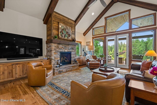 11667 N Eastshore Dr, Hayden, ID 83835 - living area with high vaulted ceiling, wood finished floors, beamed ceiling, plenty of natural light, and a fireplace