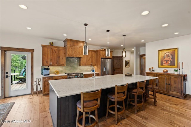 11667 N Eastshore Dr, Hayden, ID 83835 - kitchen featuring stainless steel fridge, stove, light wood-style floors, a spacious island, and recessed lighting