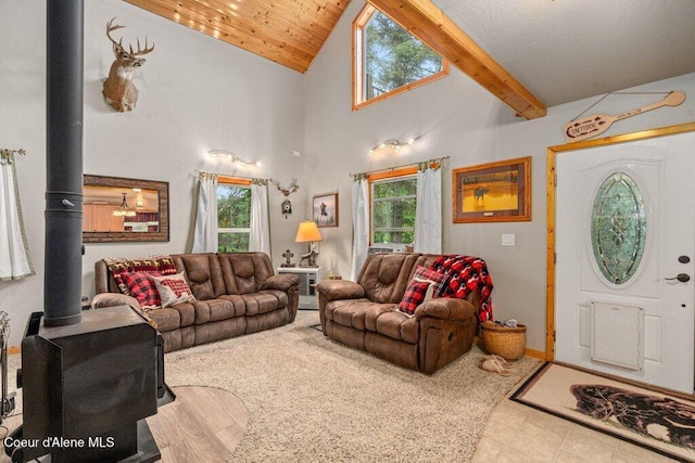 20264 Coeur Dalene River Rd, Kingston, ID 83839 - living room featuring a wood stove, plenty of natural light, high vaulted ceiling, beam ceiling, and tile patterned floors