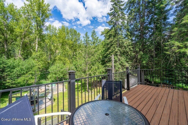 20264 Coeur Dalene River Rd, Kingston, ID 83839 - wooden deck with a wooded view, outdoor dining area, and a lawn