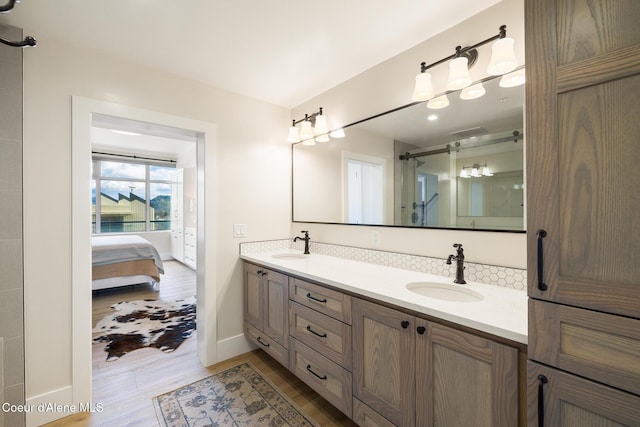 201 N 1st St # 1006, Coeur Dalene, ID 83814 - bathroom featuring wood finished floors, double vanity, connected bathroom, and a shower with door