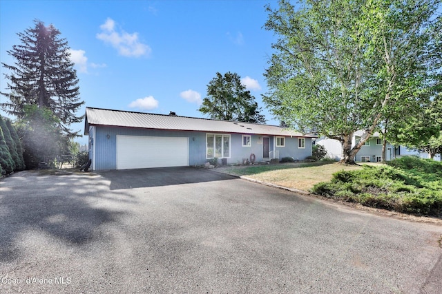 1750 N Havichur Loop, Post Falls, ID 83854 - ranch-style home with asphalt driveway, a garage, a metal roof, and a front yard