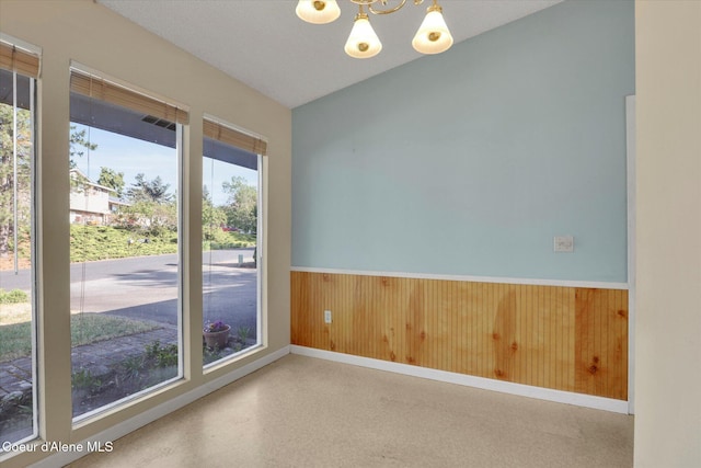 1750 N Havichur Loop, Post Falls, ID 83854 - unfurnished room featuring a wainscoted wall, a chandelier, and wooden walls