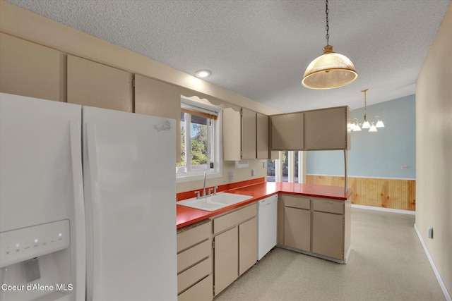 1750 N Havichur Loop, Post Falls, ID 83854 - kitchen featuring white appliances, a textured ceiling, hanging light fixtures, a chandelier, and a peninsula