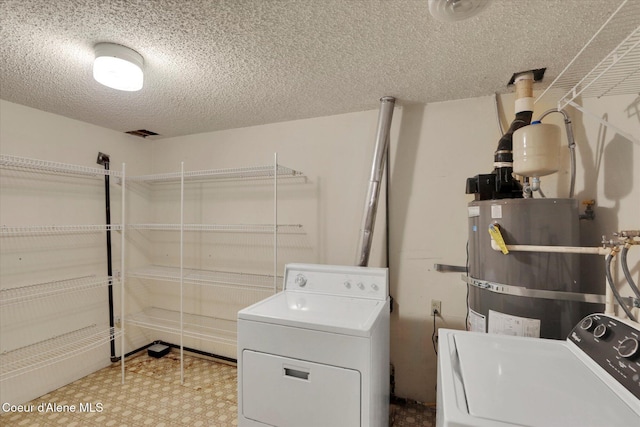 1750 N Havichur Loop, Post Falls, ID 83854 - laundry room with washing machine and dryer, secured water heater, a textured ceiling, and tile patterned floors