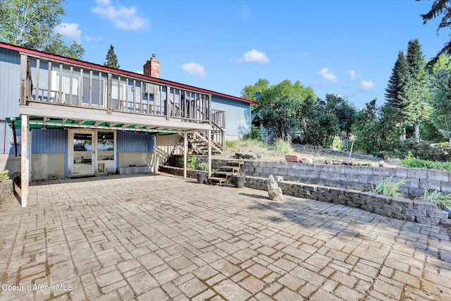 1750 N Havichur Loop, Post Falls, ID 83854 - rear view of property featuring a patio area, a deck, a chimney, and stairs