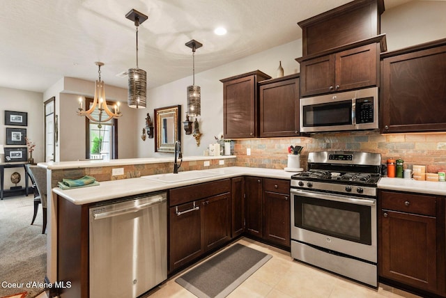 4583 Greenchain Loop Unit 5, Coeur Dalene, ID 83814 - kitchen featuring stainless steel appliances, a peninsula, dark brown cabinetry, light countertops, and tasteful backsplash