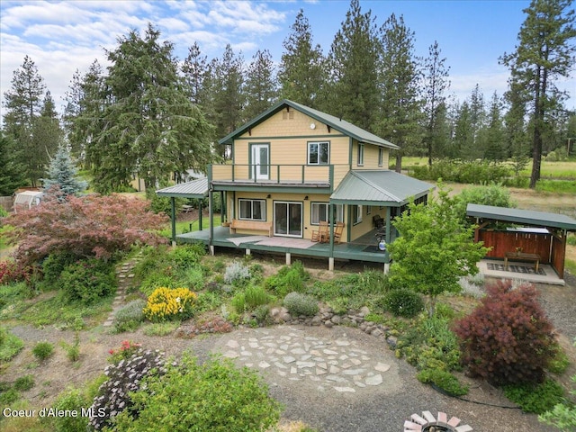 14250 W Sunmeadow Rd, Worley, ID 83876 - back of house featuring a metal roof, a deck, and view of wooded area