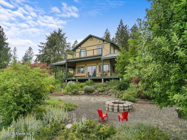 14250 W Sunmeadow Rd, Worley, ID 83876 - back of property featuring a fire pit and a porch