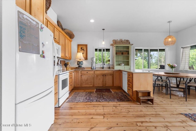 14250 W Sunmeadow Rd, Worley, ID 83876 - kitchen featuring white appliances, light wood finished floors, a peninsula, light countertops, and decorative light fixtures