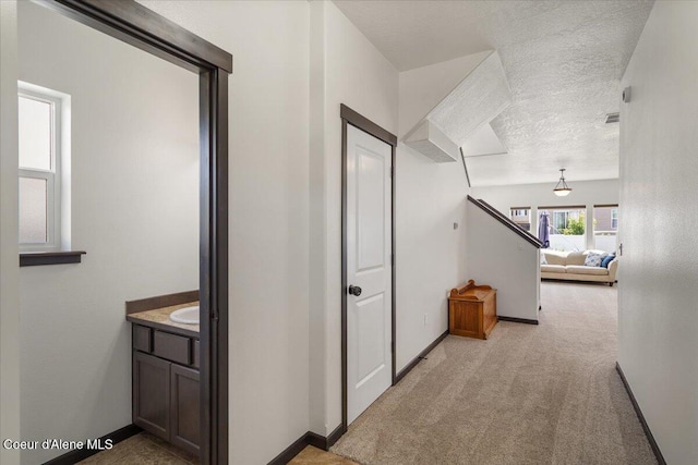 1824 E Warbler Ln, Post Falls, ID 83854 - hallway with light colored carpet, a textured ceiling, and stairway