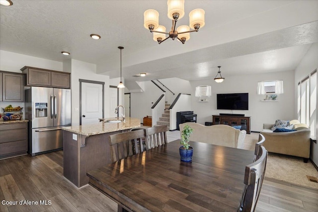 1824 E Warbler Ln, Post Falls, ID 83854 - dining room featuring dark wood finished floors, stairs, and a chandelier