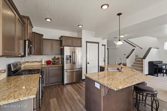 1824 E Warbler Ln, Post Falls, ID 83854 - kitchen with stainless steel appliances, open floor plan, a textured ceiling, light stone counters, and dark wood-type flooring