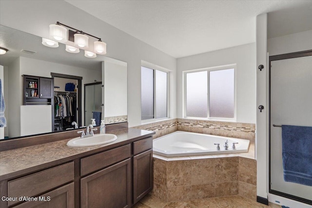 1824 E Warbler Ln, Post Falls, ID 83854 - full bathroom with vanity, a garden tub, a walk in closet, and a stall shower