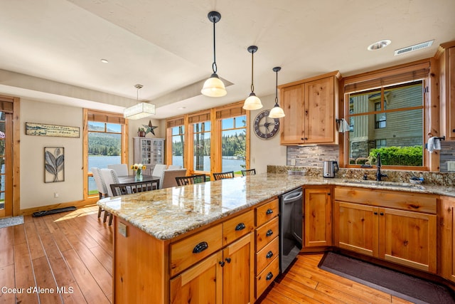 653 Dover Bay Pkwy Unit 101, Dover, ID 83825 - kitchen with dishwasher, plenty of natural light, a peninsula, and light wood-style flooring