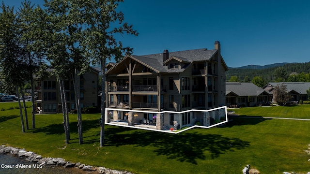 653 Dover Bay Pkwy Unit 101, Dover, ID 83825 - rear view of property featuring a lawn, a mountain view, and a balcony