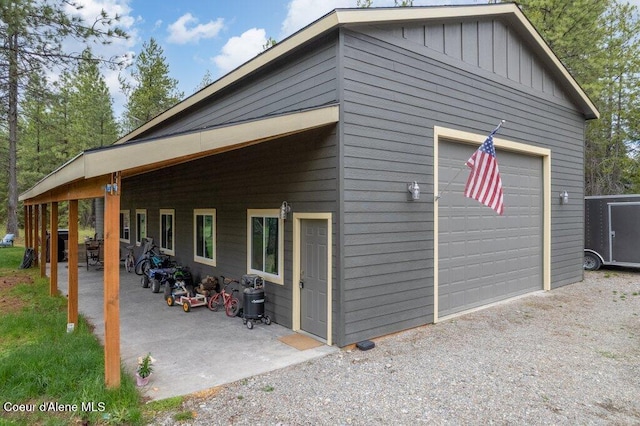 172 Wyatt Ln, Spirit Lake, ID 83869 - rear view of house featuring board and batten siding, driveway, and a patio