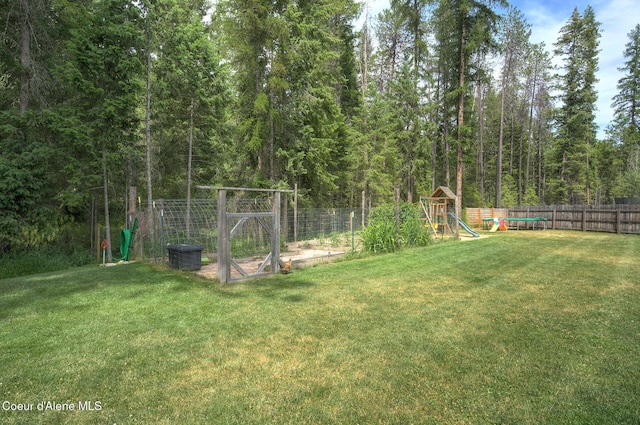 81 Mango St, Moyie Springs, ID 83845 - fenced backyard featuring a playground, a garden, and a wooded view