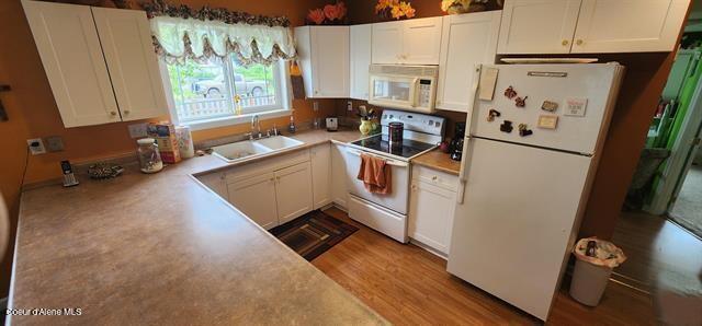 817 6th St, Kamiah, ID 83536 - kitchen with white appliances, white cabinetry, and light countertops