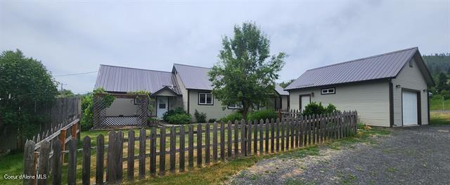 817 6th St, Kamiah, ID 83536 - view of front of house with a metal roof, an outdoor structure, and a garage
