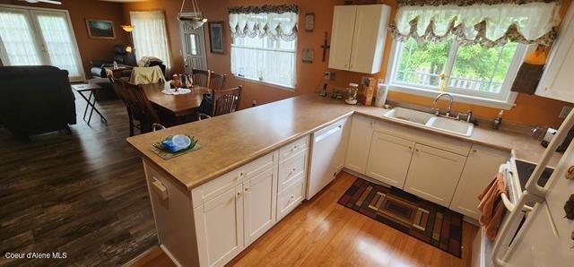 817 6th St, Kamiah, ID 83536 - kitchen with dishwasher, open floor plan, dark wood-style floors, light countertops, and a peninsula