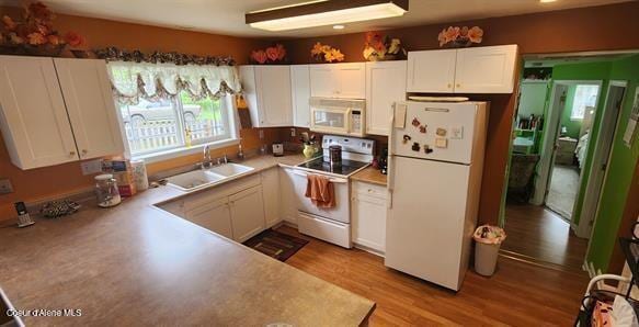 817 6th St, Kamiah, ID 83536 - kitchen featuring white appliances, white cabinets, wood finished floors, and light countertops
