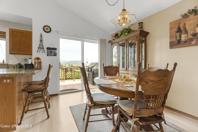635 N Divot Ave, Post Falls, ID 83854 - dining room featuring light wood-type flooring, vaulted ceiling, and a chandelier