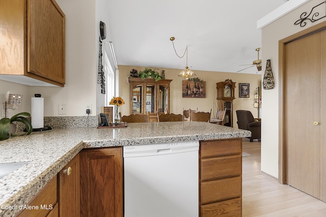 635 N Divot Ave, Post Falls, ID 83854 - kitchen with white dishwasher, a peninsula, brown cabinetry, and ceiling fan