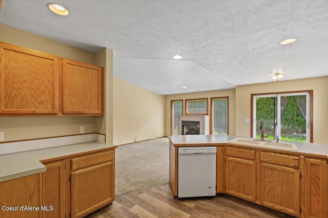 879 E Cloverleaf Dr, Hayden, ID 83835 - kitchen featuring white dishwasher, a textured ceiling, open floor plan, a fireplace, and wood finished floors
