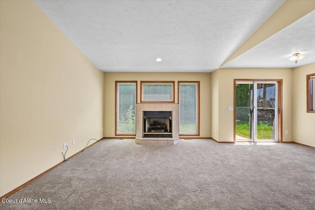 879 E Cloverleaf Dr, Hayden, ID 83835 - unfurnished living room with carpet, a textured ceiling, and a tile fireplace