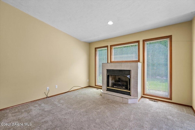 879 E Cloverleaf Dr, Hayden, ID 83835 - unfurnished living room featuring carpet flooring, a tiled fireplace, and a textured ceiling