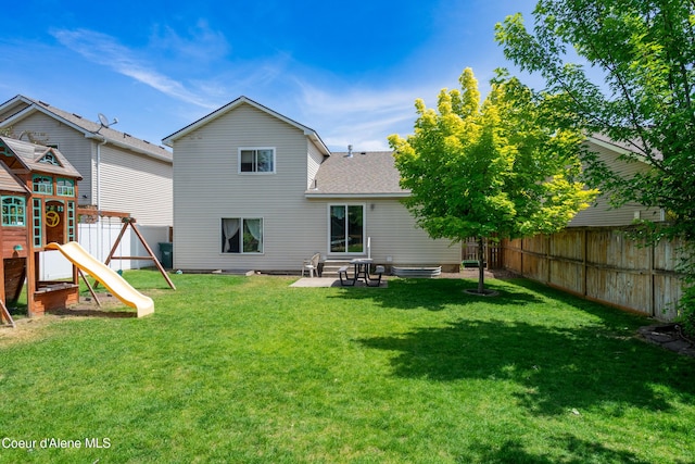 1817 N Chehalis St, Post Falls, ID 83854 - back of property with a shingled roof, a fenced backyard, and a playground