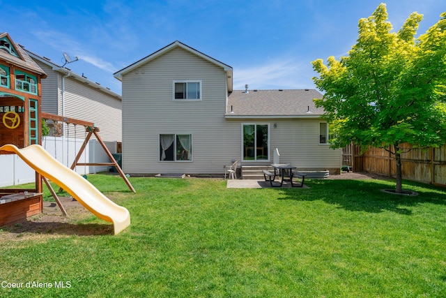 1817 N Chehalis St, Post Falls, ID 83854 - back of property featuring a playground, entry steps, a fenced backyard, roof with shingles, and a patio