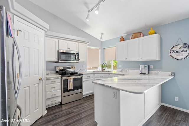 1817 N Chehalis St, Post Falls, ID 83854 - kitchen with stainless steel appliances, a peninsula, vaulted ceiling, dark wood finished floors, and white cabinetry