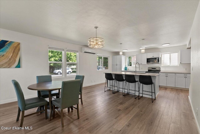 202 S 18th St, Coeur Dalene, ID 83814 - dining space with light wood finished floors, a wall unit AC, and a chandelier