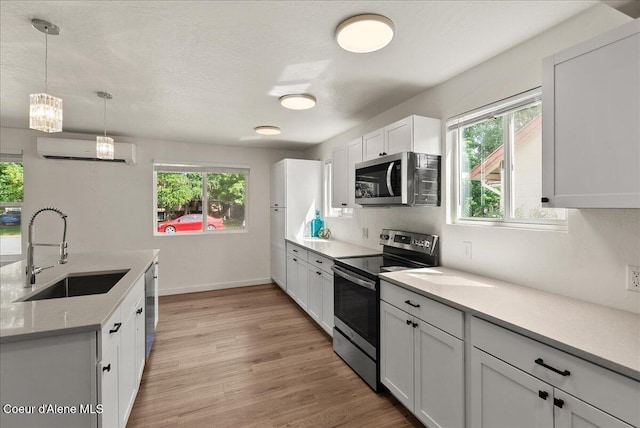 202 S 18th St, Coeur Dalene, ID 83814 - kitchen featuring appliances with stainless steel finishes, an AC wall unit, healthy amount of natural light, and light wood-style flooring
