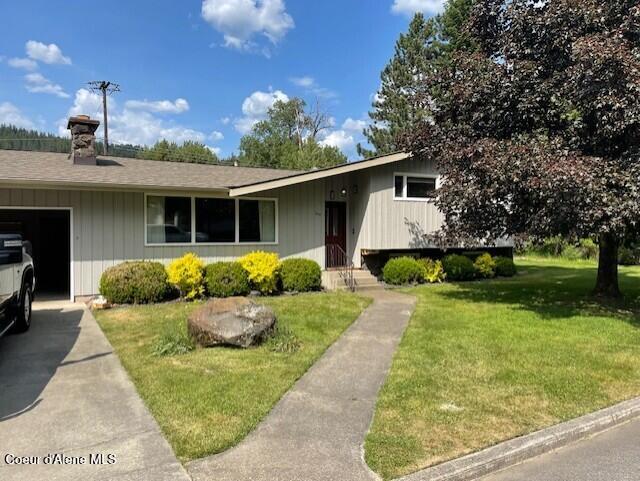 204 W Oak Ave, Osburn, ID 83849 - view of front facade featuring a front lawn, a garage, a chimney, and driveway