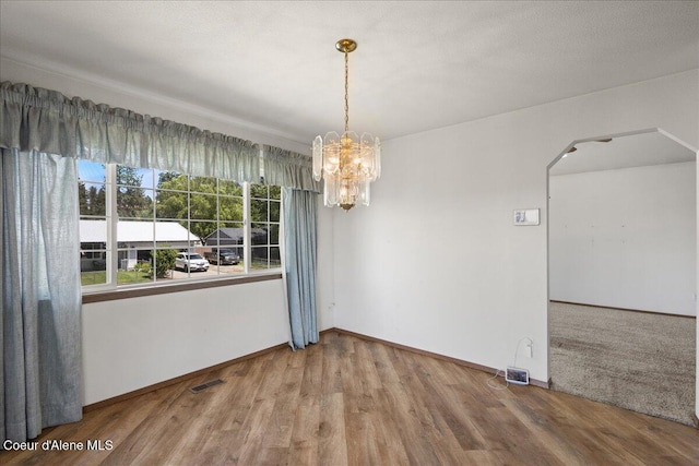401 W 19th Ave, Post Falls, ID 83854 - unfurnished dining area with arched walkways, a chandelier, and wood finished floors