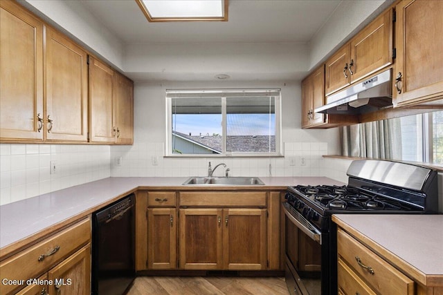 401 W 19th Ave, Post Falls, ID 83854 - kitchen with gas stove, black dishwasher, under cabinet range hood, light wood-type flooring, and decorative backsplash