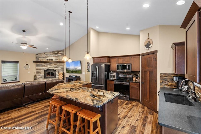 2130 E Bellamy Rd, Athol, ID 83801 - kitchen featuring stainless steel appliances, a center island, wood finished floors, a ceiling fan, and a breakfast bar