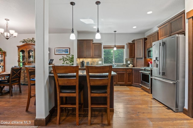 1431 W Ashmont Way, Coeur Dalene, ID 83815 - kitchen featuring high end appliances, wood finished floors, tasteful backsplash, a chandelier, and recessed lighting