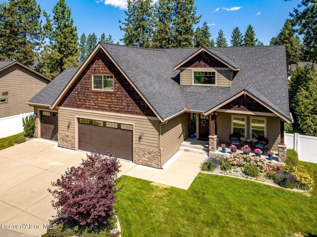 1431 W Ashmont Way, Coeur Dalene, ID 83815 - craftsman-style house with roof with shingles, concrete driveway, stone siding, and covered porch