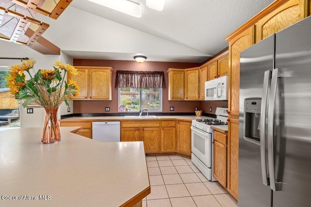 18914 W Riverview Dr, Post Falls, ID 83854 - kitchen with white appliances, lofted ceiling, light tile patterned floors, and light countertops